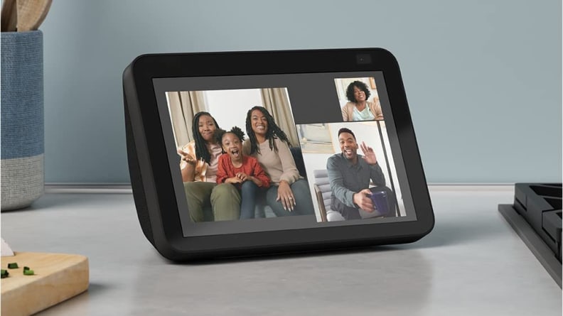 Smiling family connecting to each other via video call on smart tablet sitting on counter.