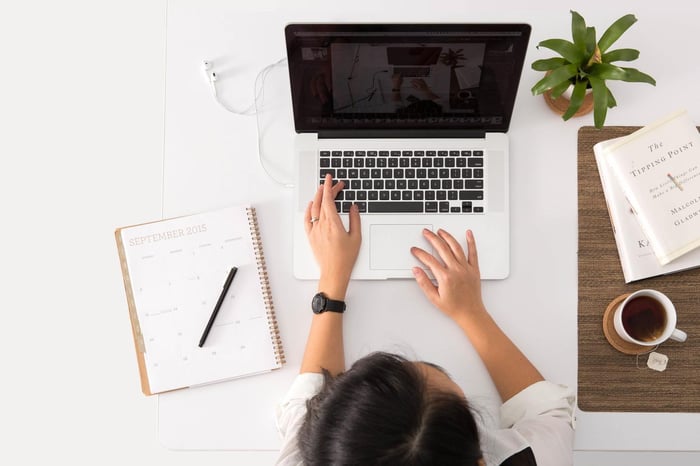 Girl typing on a laptop with a white background